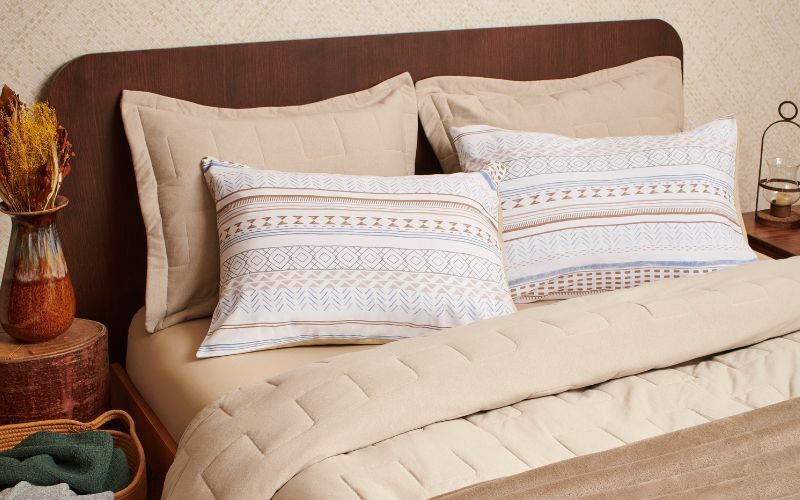Camas com travesseiros decorativos e colcha neutra