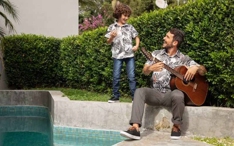 pai-filho-na-beira-da-piscina-tocando-violao