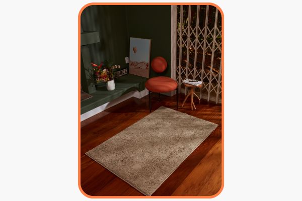 decoração mid century com um assento laranja e um tapete creme