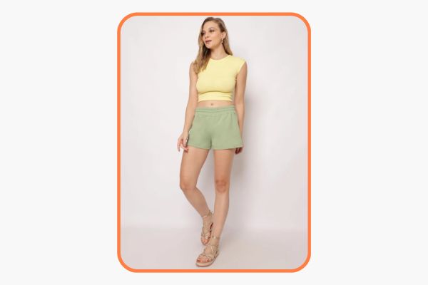 mulher veste look verde e amarelo em cores claras, conhecidas como tons pastel