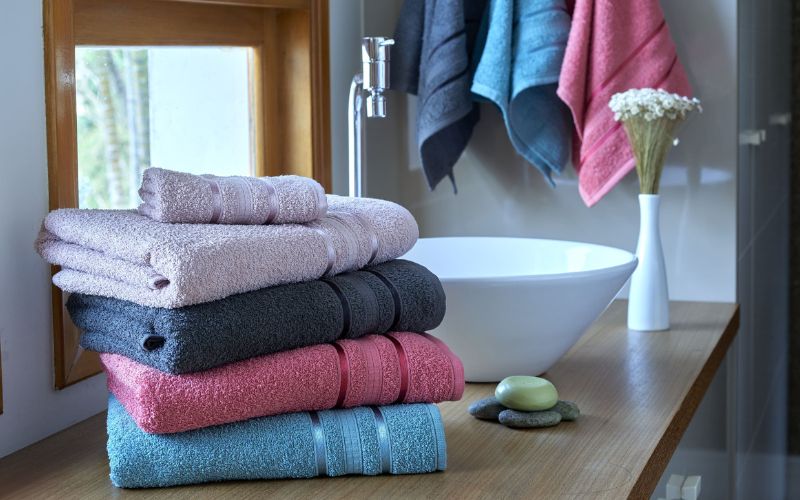 toalhas de banho empilhadas na pia do banheiro