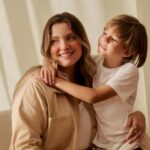 Mãe e filho sorrindo em ambiente aconchegante