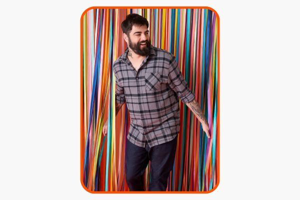 Homem sorridente posando em fundo colorido com fitas