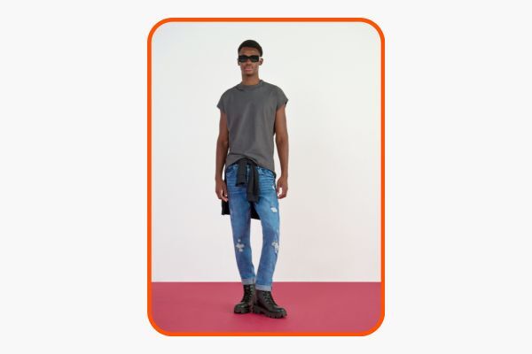 Modelo masculino com camiseta e jeans rasgado