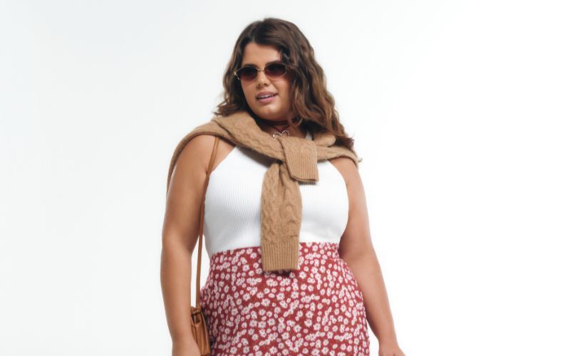 Mulher estilosa com óculos e saia floral na moda.