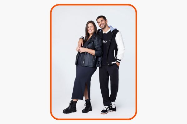 Casal posando com roupas de moda tênis e jaqueta.