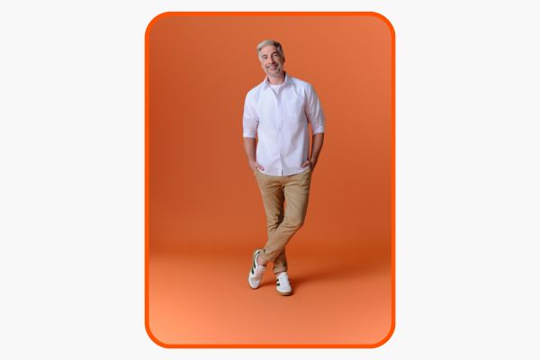 Homem sorridente em fundo laranja, estilo moderno