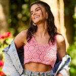 Jovem sorrindo com blusa de crochê rosa