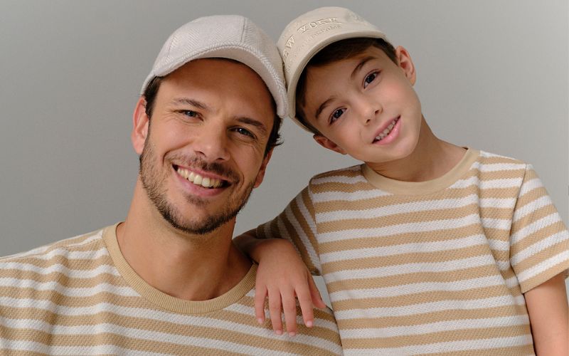 Pai e filho com camisetas listradas sorrindo
