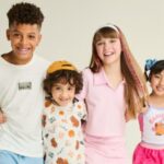 Quatro crianças em roupas coloridas sorrindo