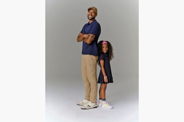 Pai e filha sorrindo, vestidos de forma casual.