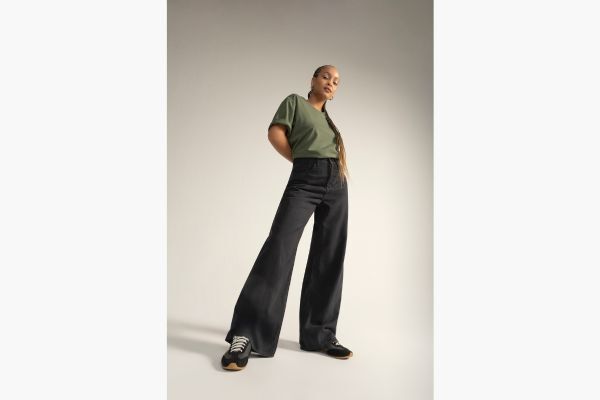 Modelo em calça larga e camiseta verde