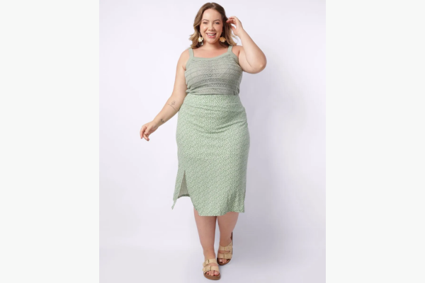 Modelo plus size vestindo saia verde e blusa cinza