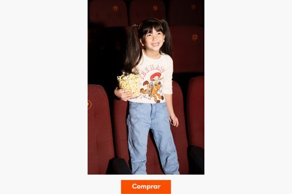 Menina com pipoca em cinema sorrindo