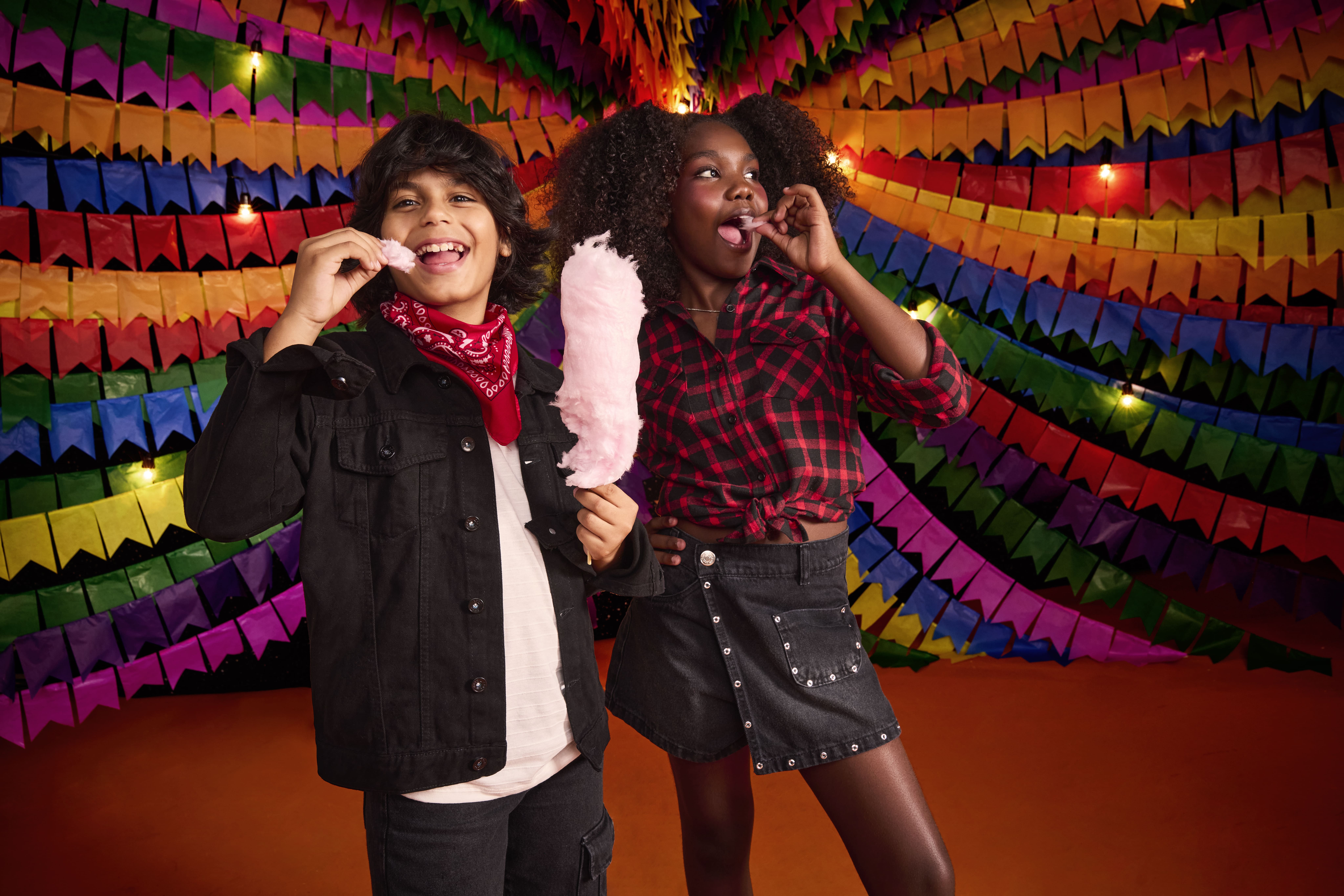 Crianças se divertindo em festa com algodão doce.