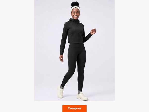 Mulher sorrindo com roupa de treino preta