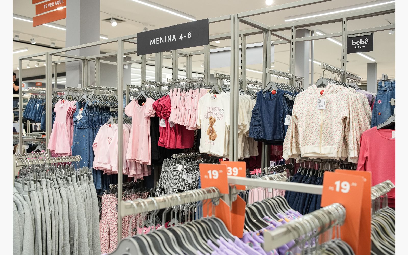 Loja de roupa com roupa infantil de menina 4 a 8 anos em exposição: vestidinho, camiseta estampada, blusas infantis, moletom infantil