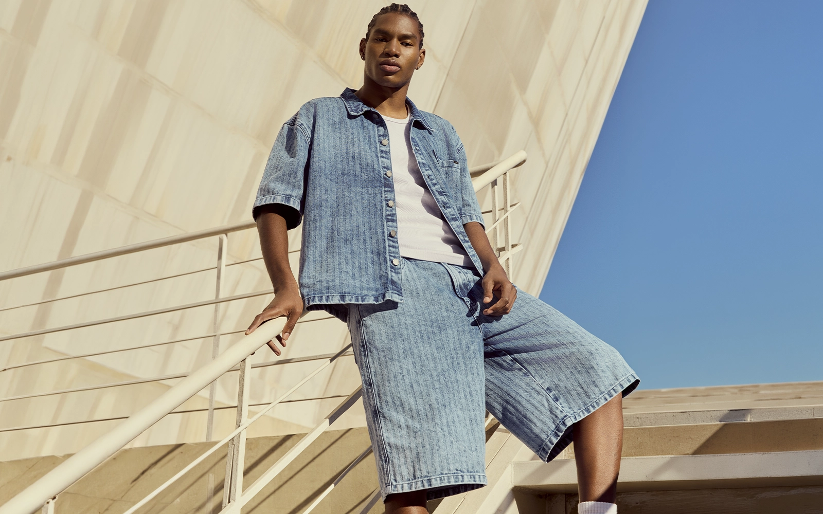 Homem com bermuda jeans e camisa