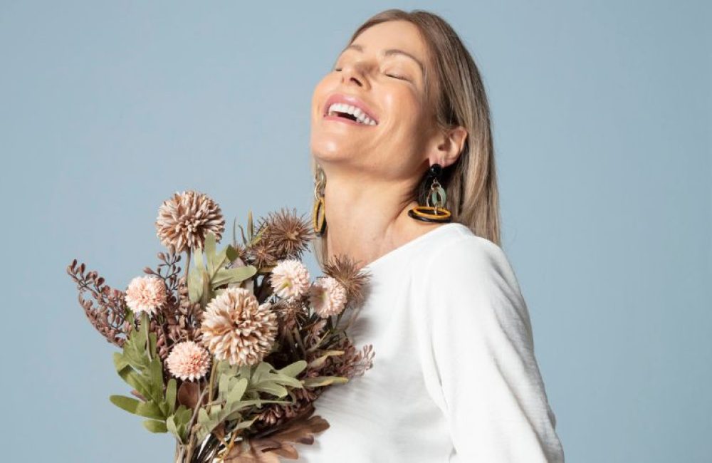 mulher feliz com um buque de flores que recebeu no dia das mulheres