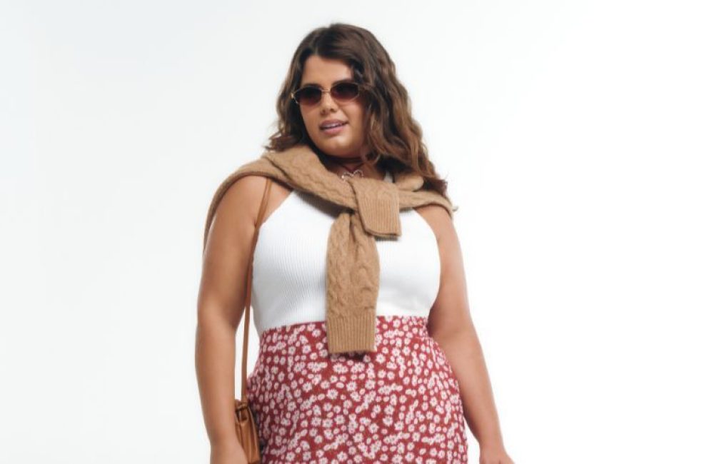 Mulher estilosa com óculos e saia floral na moda.