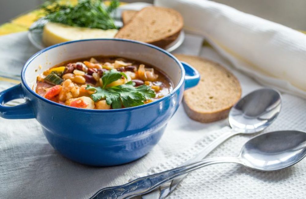 tigela de sopa com fatias de pão ao lado