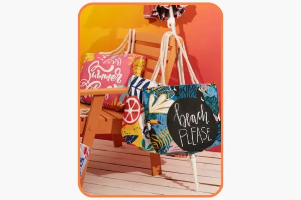 acessórios para levar para a praia: bolsa, guarda-sol e toalha. dispostos sobre uma cadeira de madeira