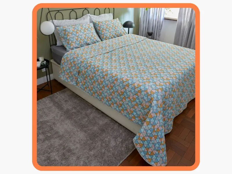 cama de casal com cobreleito em edredom com padrões geométricos