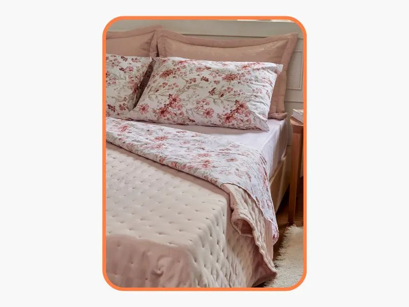 cama arrumada com uma colcha floral