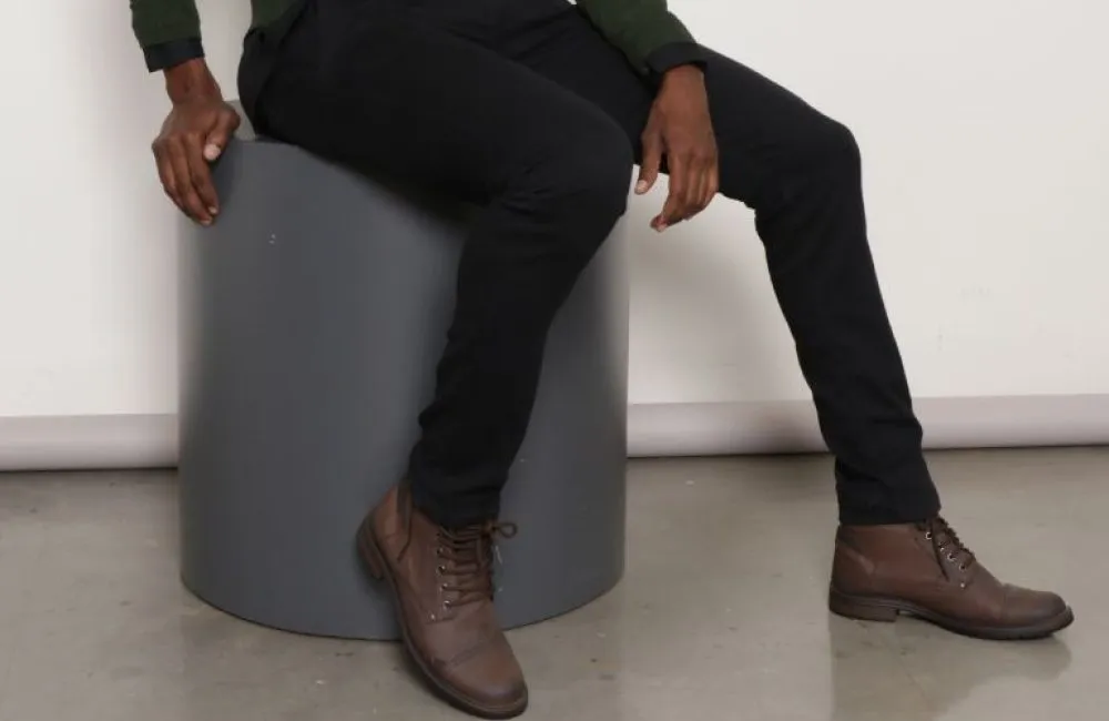 Homem sentado vestindo botas masculinas marrom