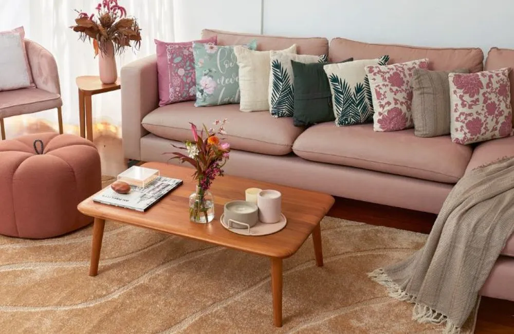 Decoração na sala de estar, mesa marrom e um sofá com muitas almofadas